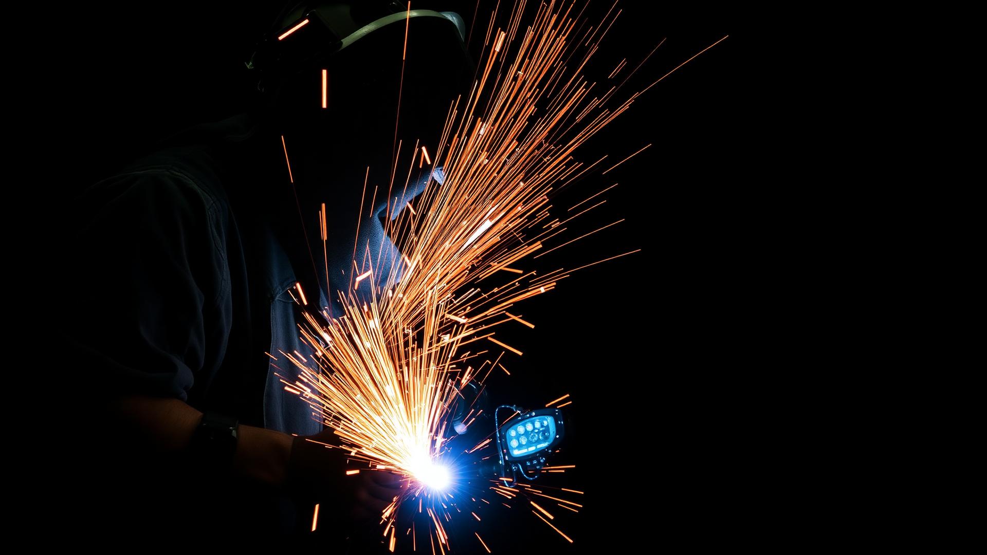 Professional welding in St. Kitts Welder TIG welding a steel frame with sparks flying in St. Kitts